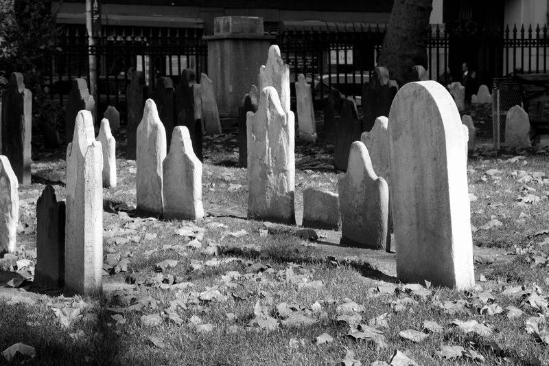 several headstones in a cemetery with trees in the background