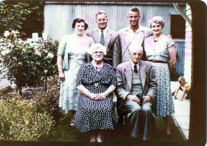 a family posing for a picture in front of a house