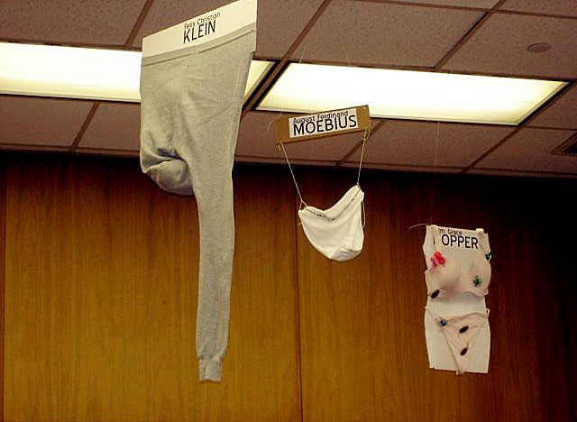 several pairs of underwear hanging from the ceiling in an office
