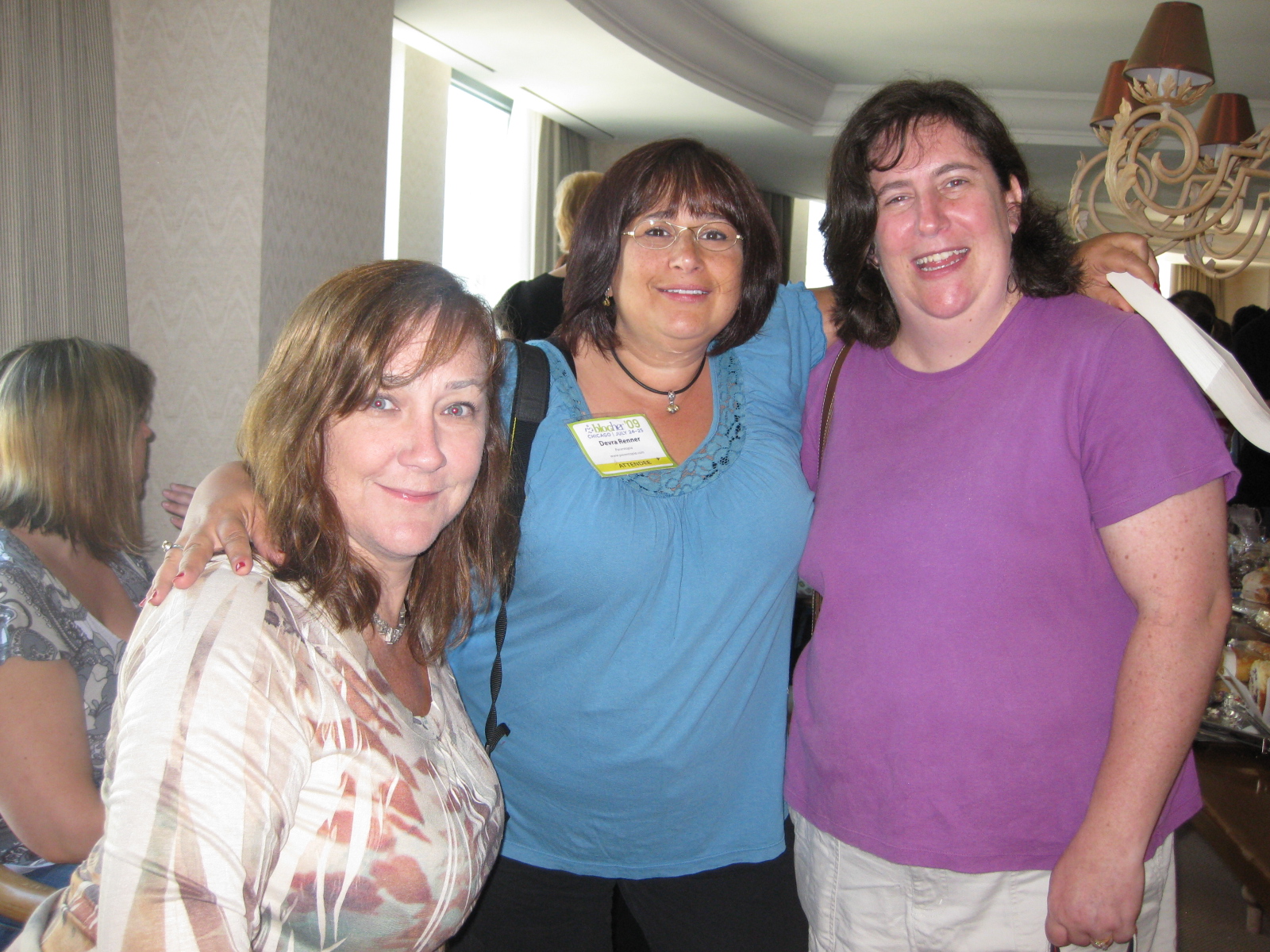 three ladies standing together in the el room