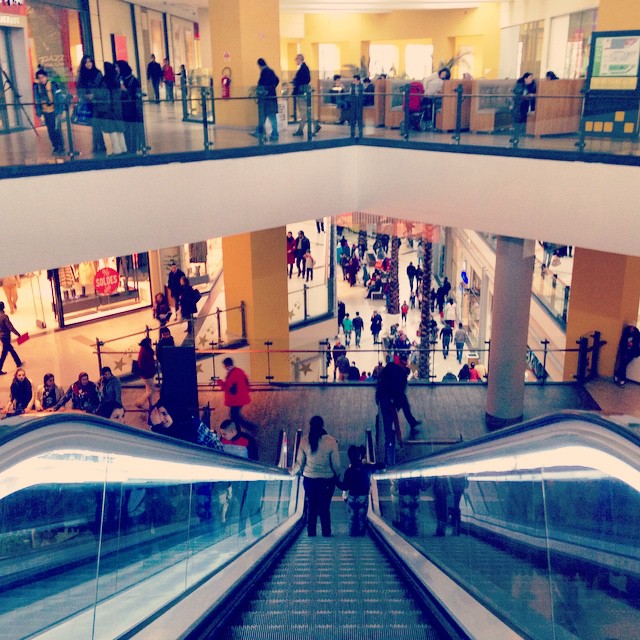 the escalators in a mall are crowded with people