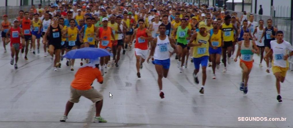 a group of people running in a race with an umbrella