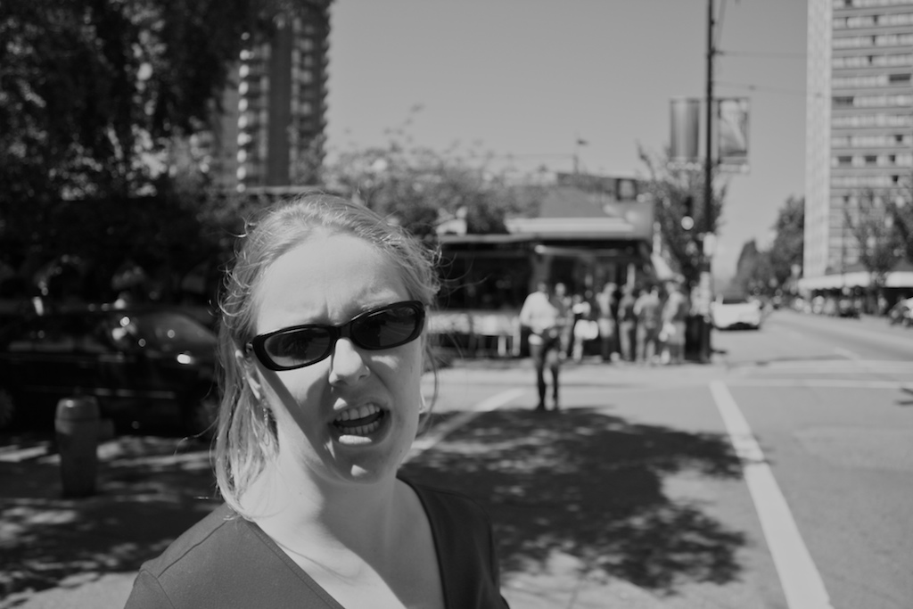 a girl on the street in sunglasses making a face