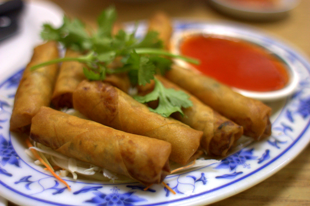 spring rolls with sauce and lettuce on plate