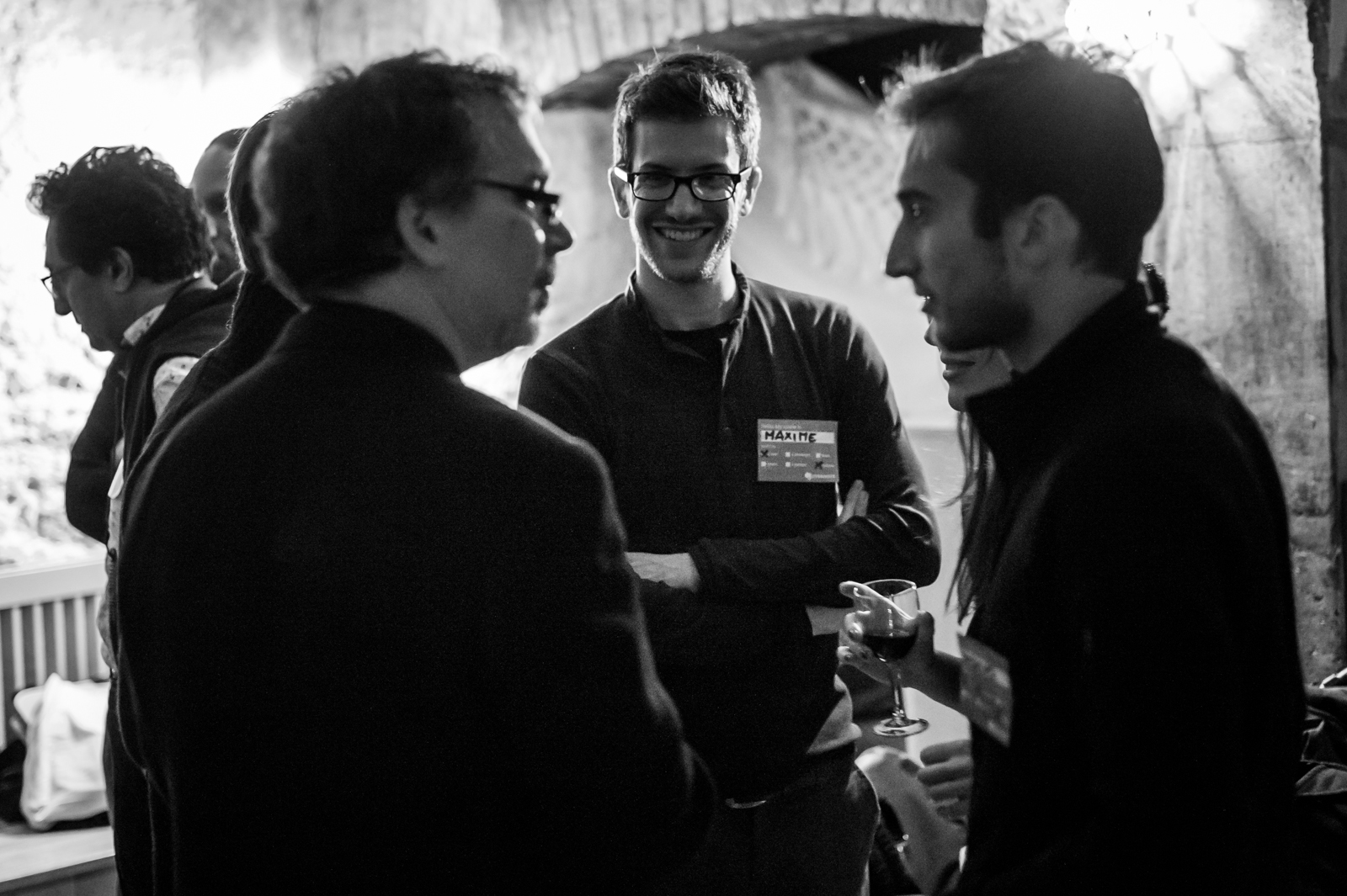two men are talking in a group at an event