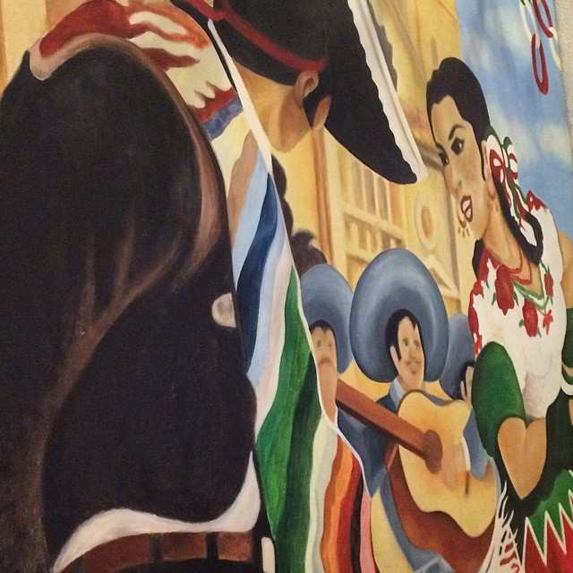 the painting depicts a woman holding a fan and other women with flags