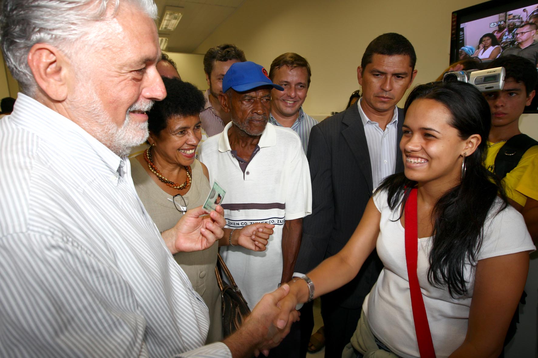 a man shaking hands with a woman in front of some other people