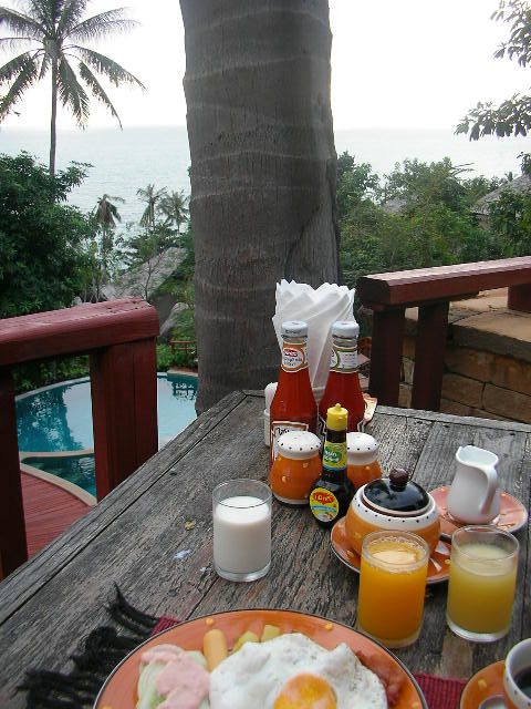 the breakfast is on the table outside with the ocean in the background
