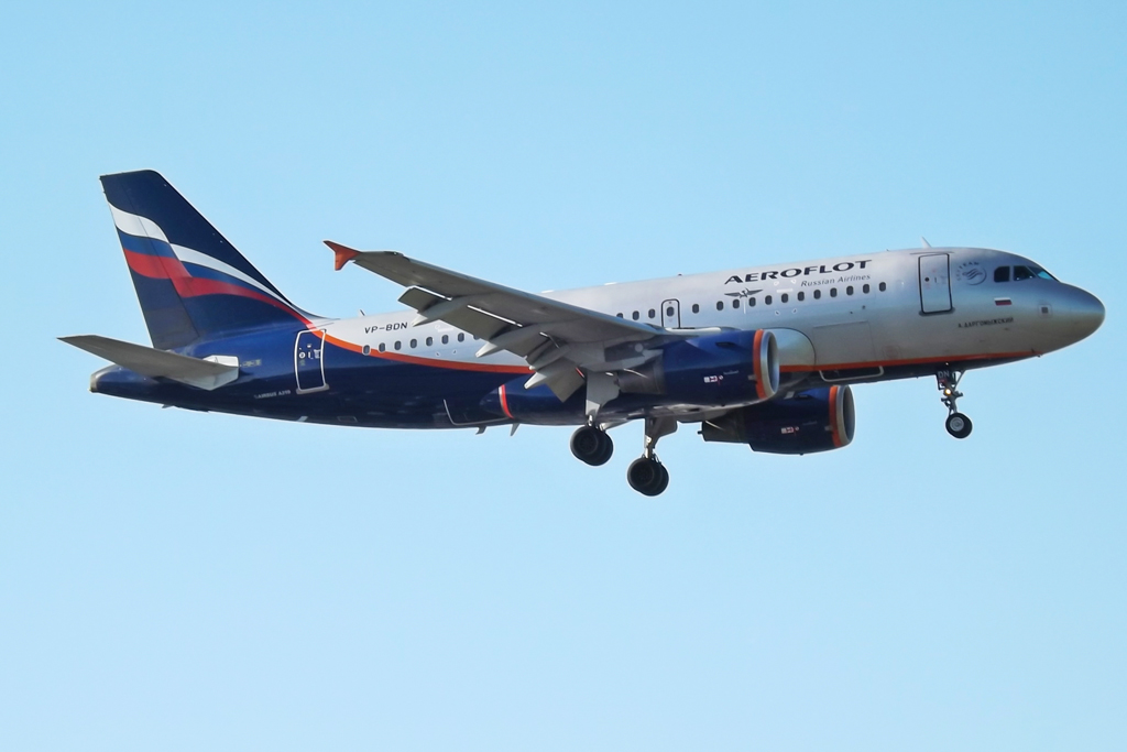 a blue and white airplane flying through the air