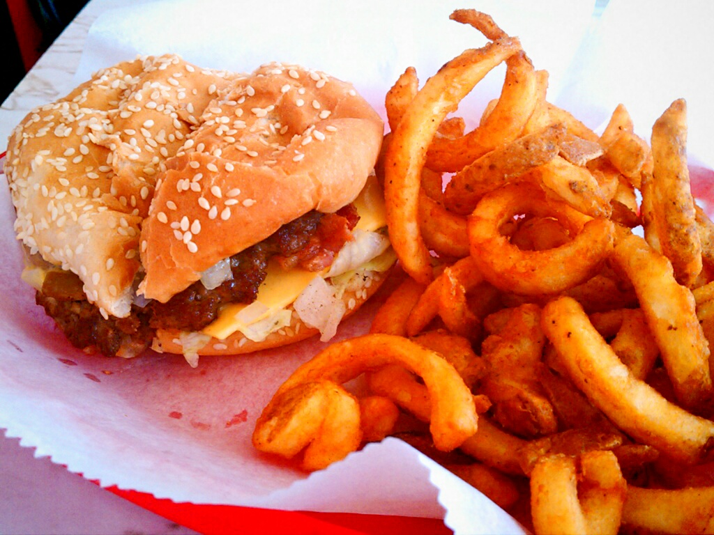 a hamburger and fries are sitting on top of wax paper