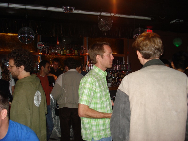 a large crowd of men are standing in front of a bar