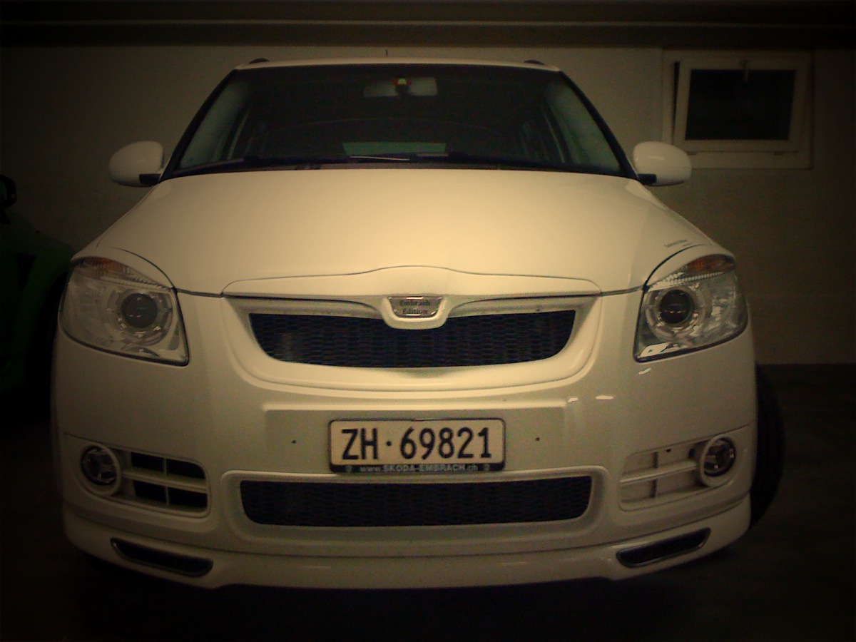 a white car with headlights on parked in a garage