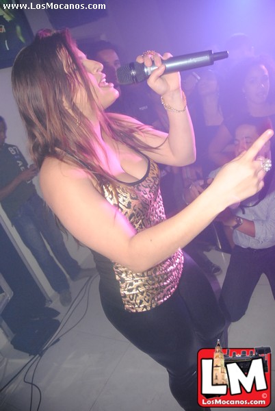 a woman in a club dancing holding a microphone