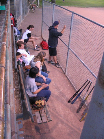 baseball players sit on the bleachers and look around