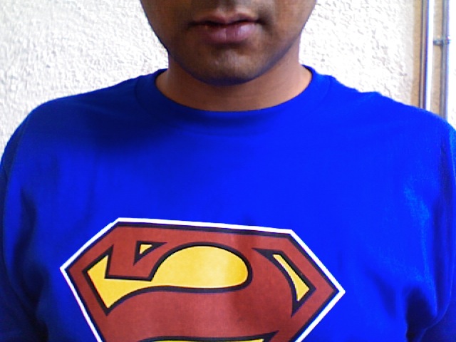 a young man is wearing a superman shirt