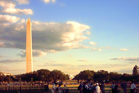 many people gather in front of the washington monument on a sunny day
