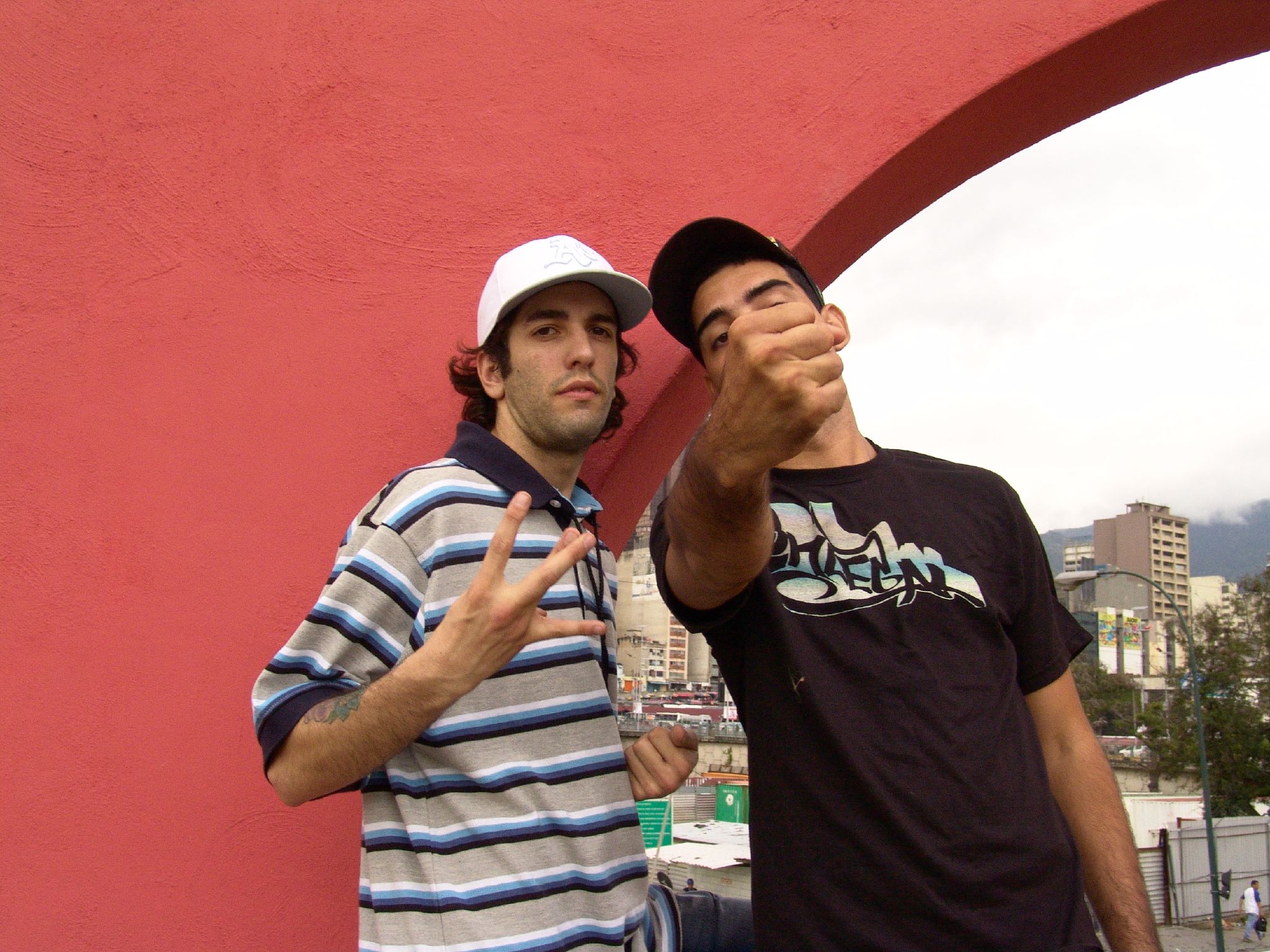 two guys pose for a po near a sculpture