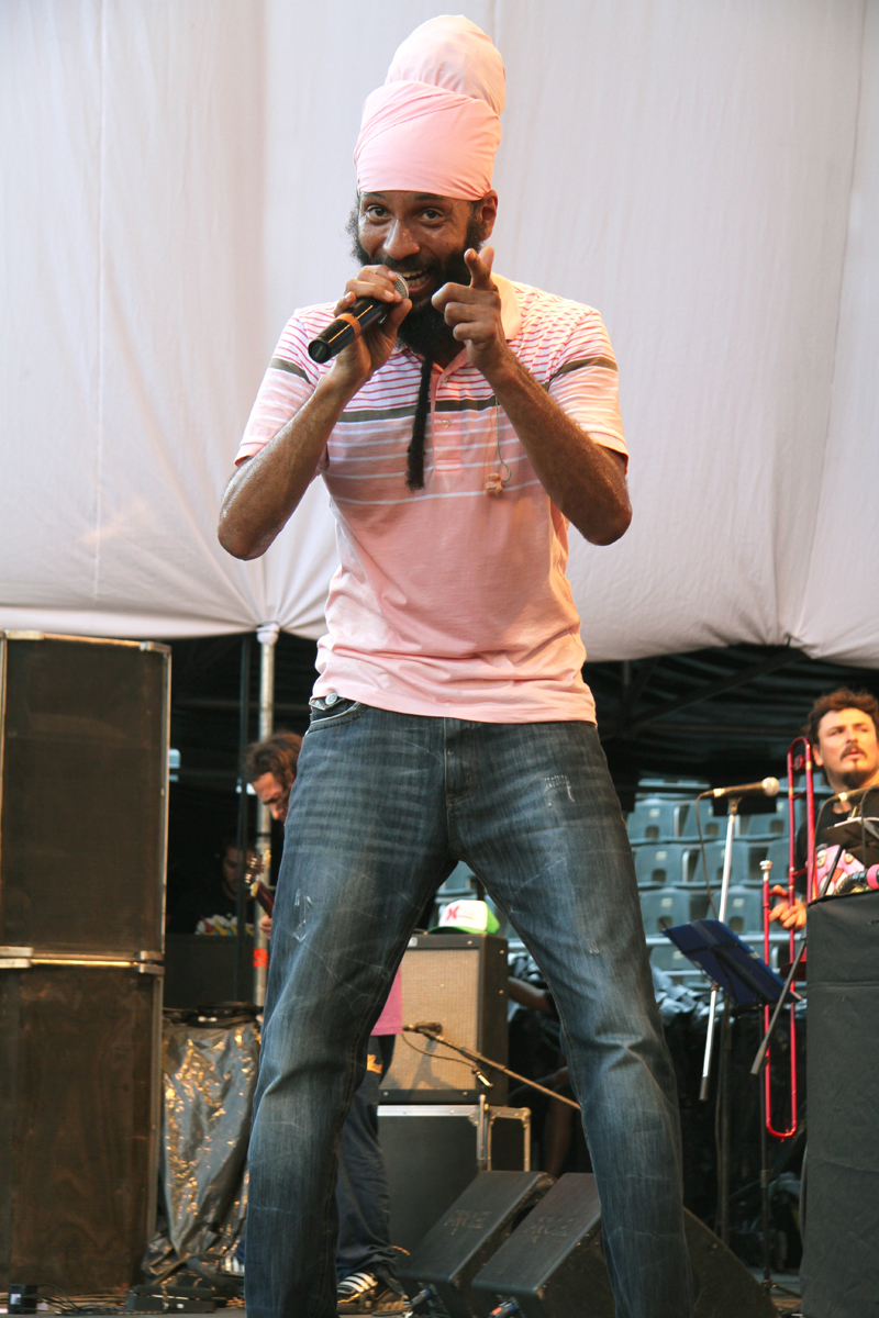 a man standing with microphone on stage and singing into the crowd