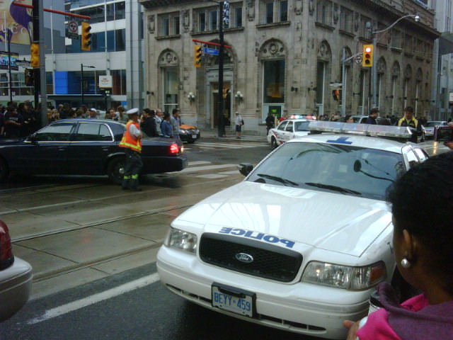 a police car is stopped in front of a busy city street
