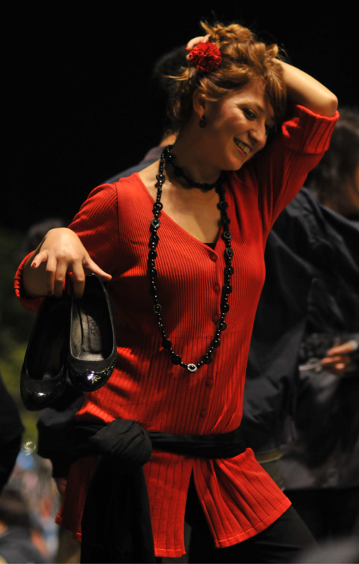 a woman wearing a red top with her hand on her head
