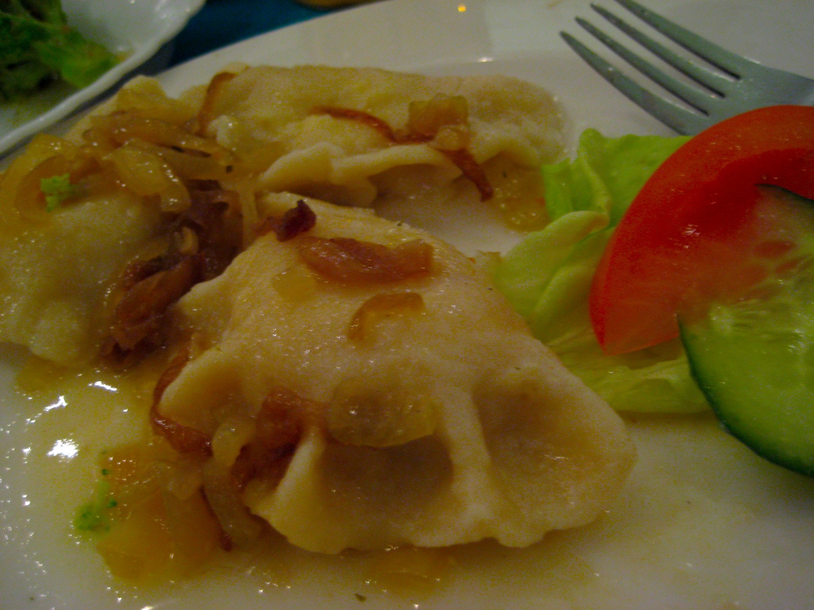 this is an image of some dumplings on a plate with veggies and sauce