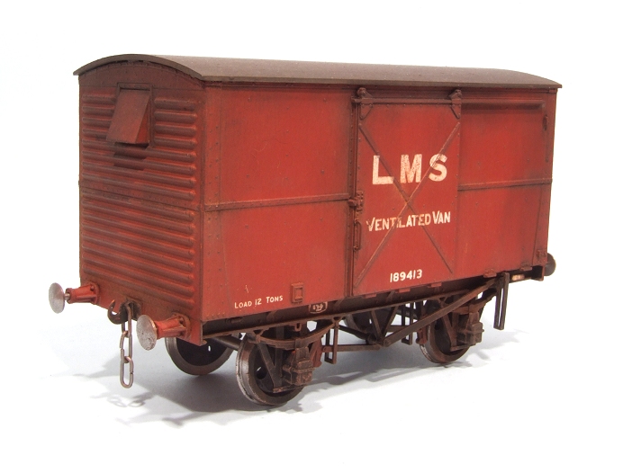 an antique red boxcar sits on a white surface