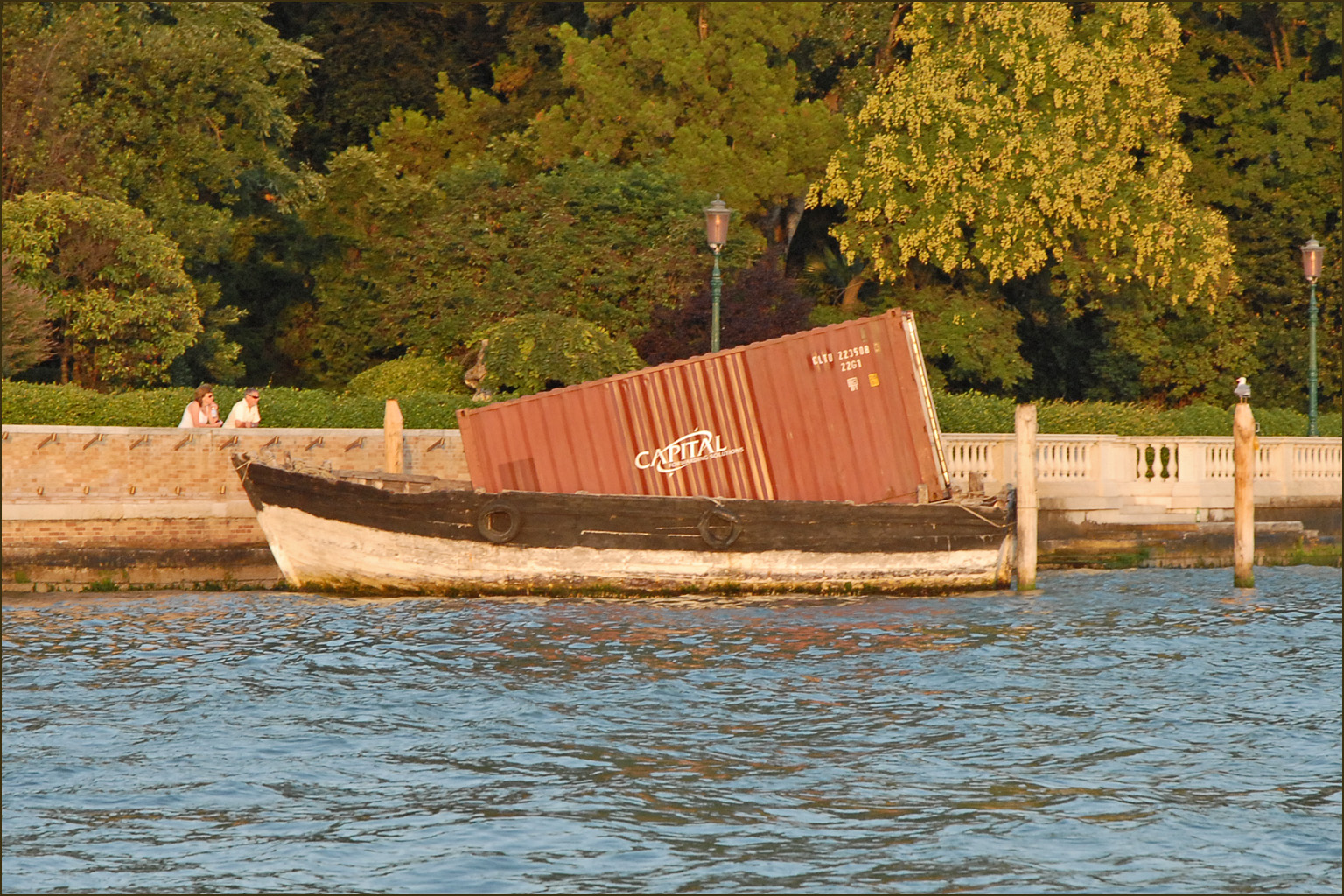 a barge that is sitting in the water with trees in the background