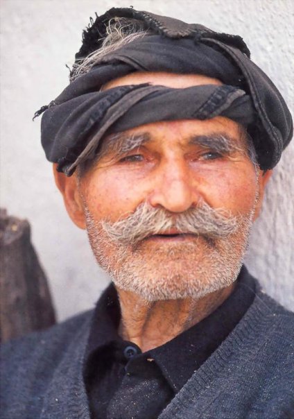 an old man with white beard wearing a turban