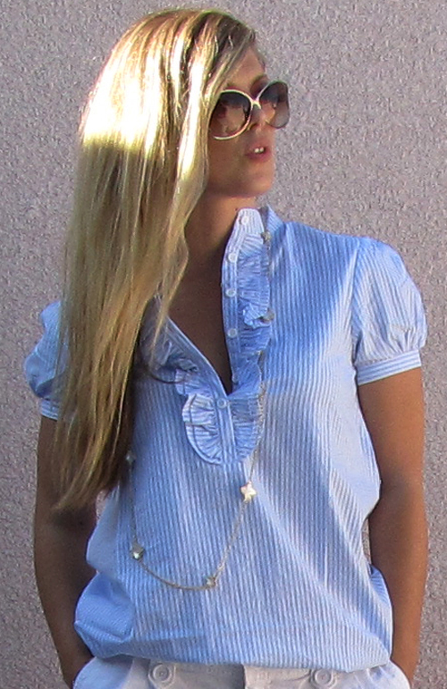 a young blond woman wearing blue clothes and white shorts