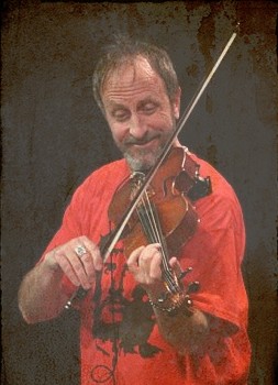 an older man holding a violin posing for a po