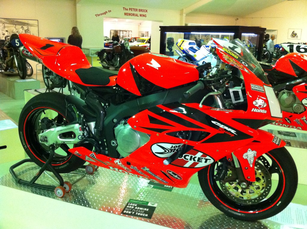 a red motorcycle sitting on display inside of a building