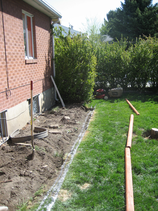 the back side of a house and a large pipe on the lawn