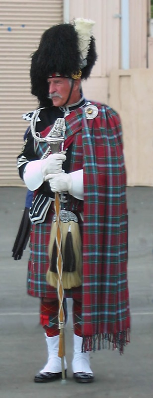 a man wearing a large kilt in a red plaid coat