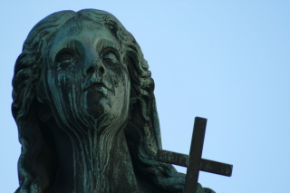 statue of woman with crucifix on her neck