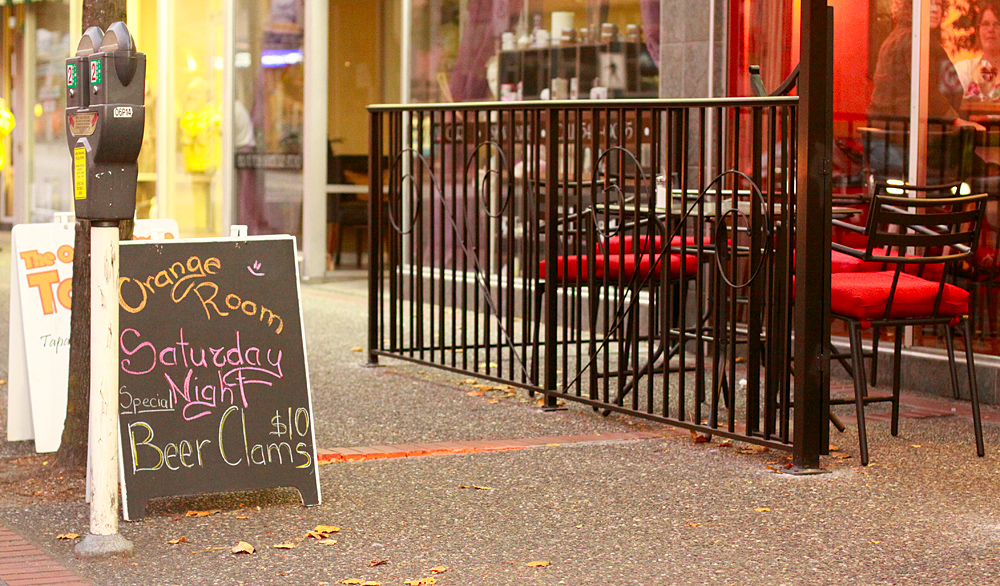 a restaurant sign with graffiti on it next to a parking meter