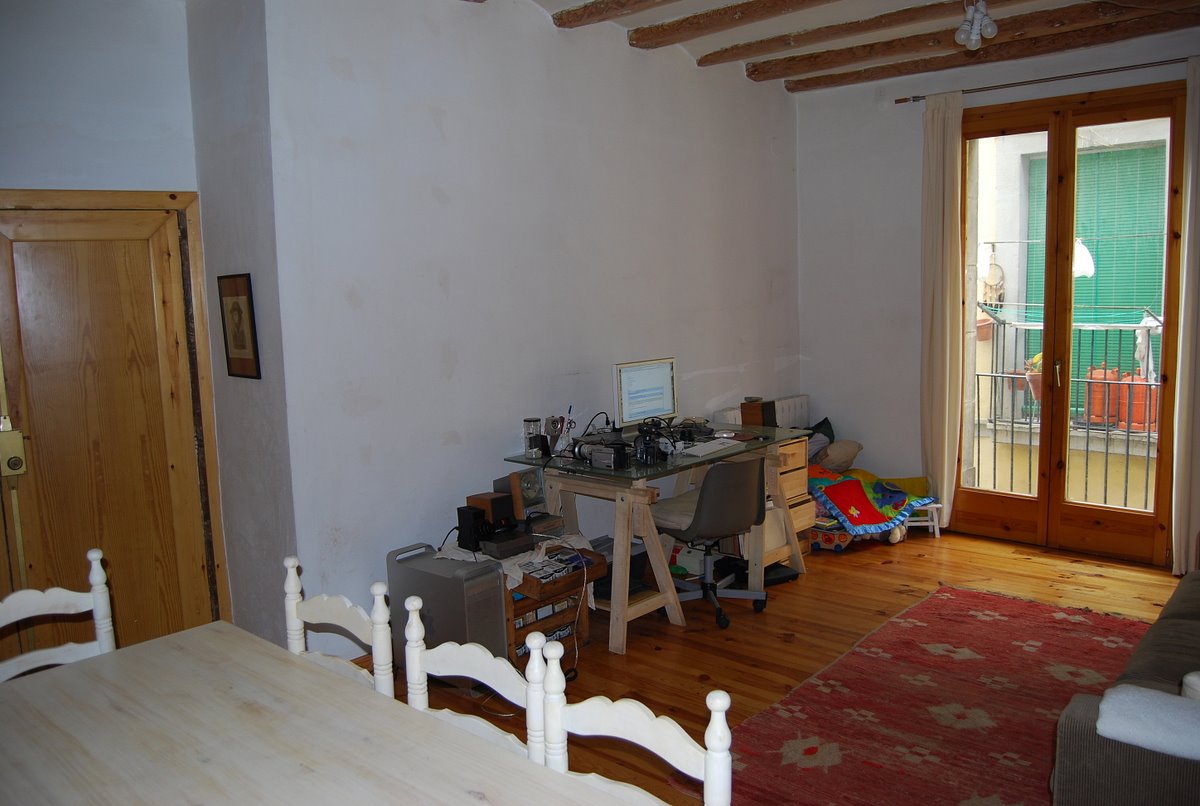 a room with a wooden floor and a small table and some chairs