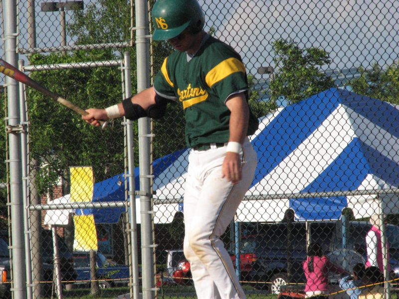 a young man playing baseball hits the ball