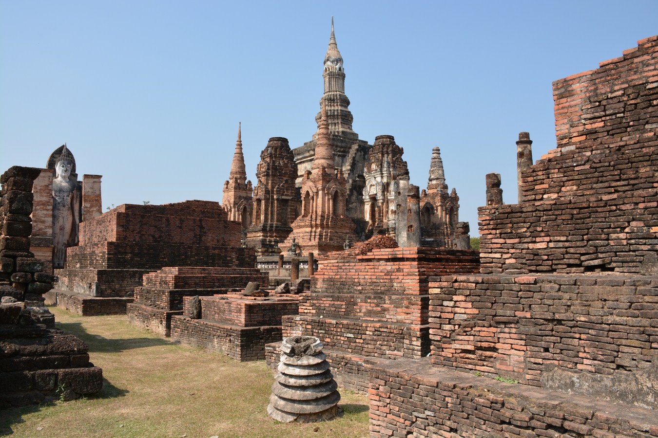 a large, brick building surrounded by ruins with towers