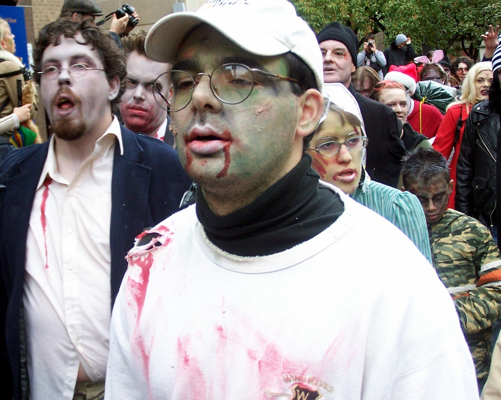 the man in the white shirt is wearing paint and standing by others