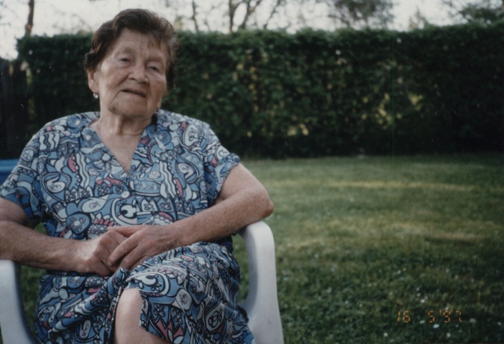 an elderly woman sitting in a lawn chair