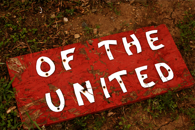 a red sign that says of the united lying on the ground