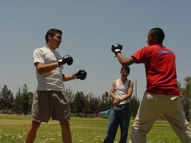 two men and a girl in a field with a red shirt