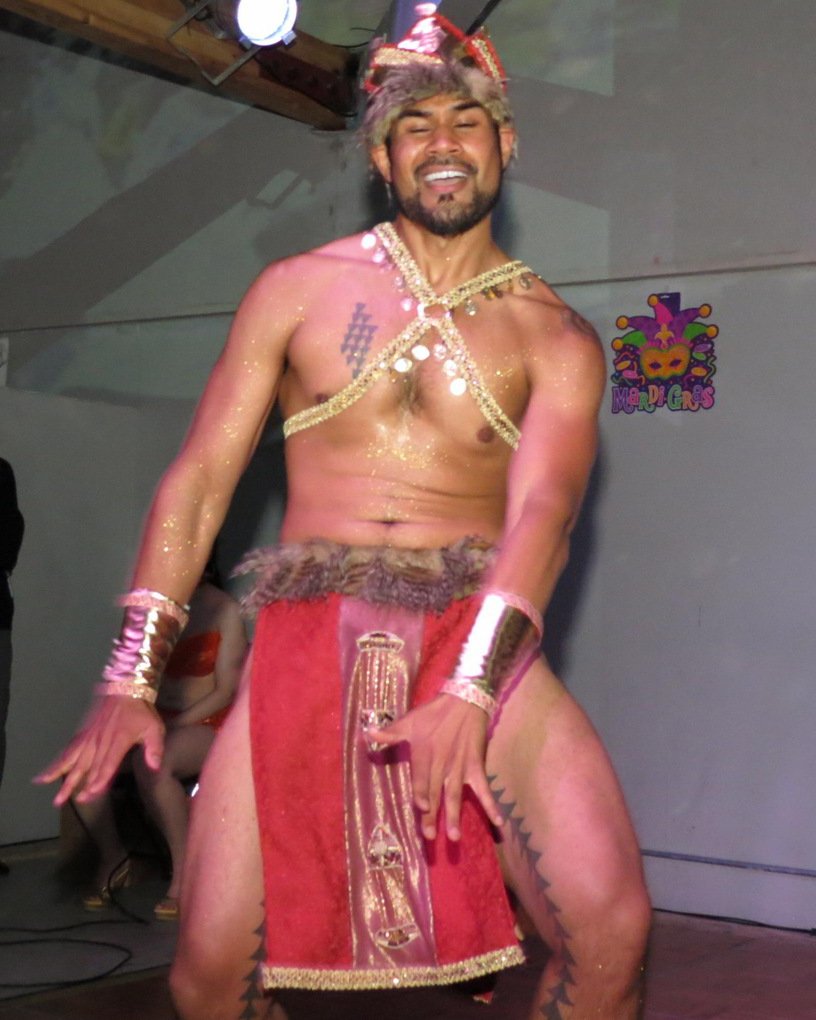 an indian man in the foreground with white skin and gold tattoos on his body