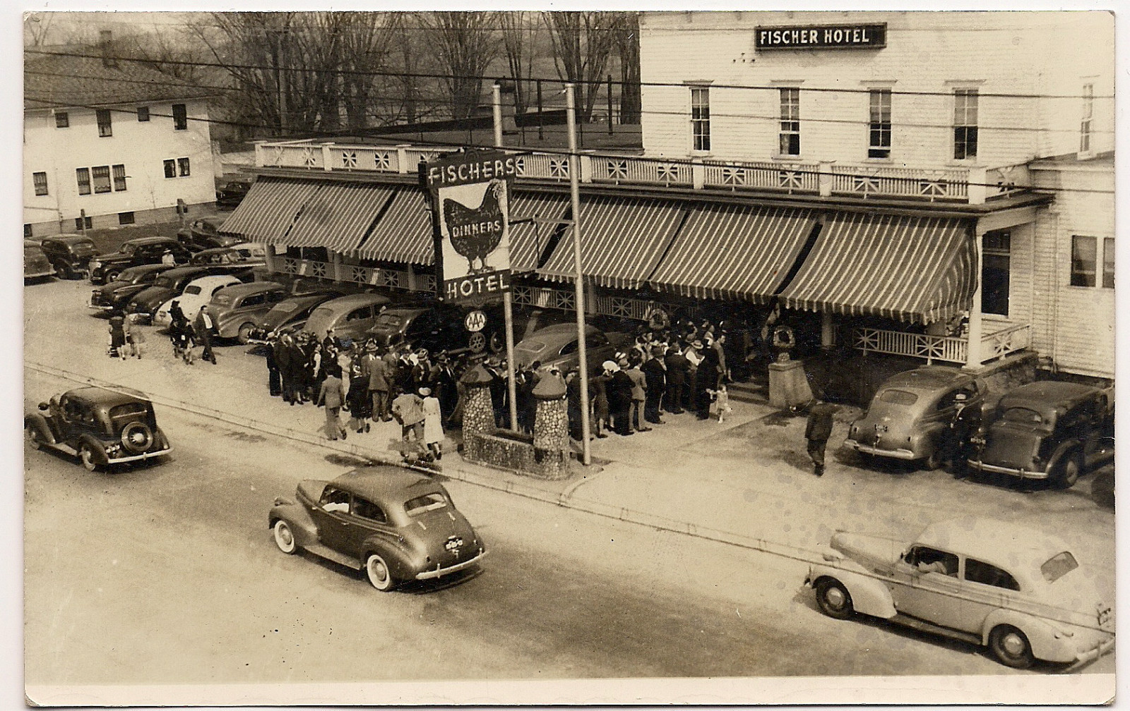 a black and white po of people and cars on the road