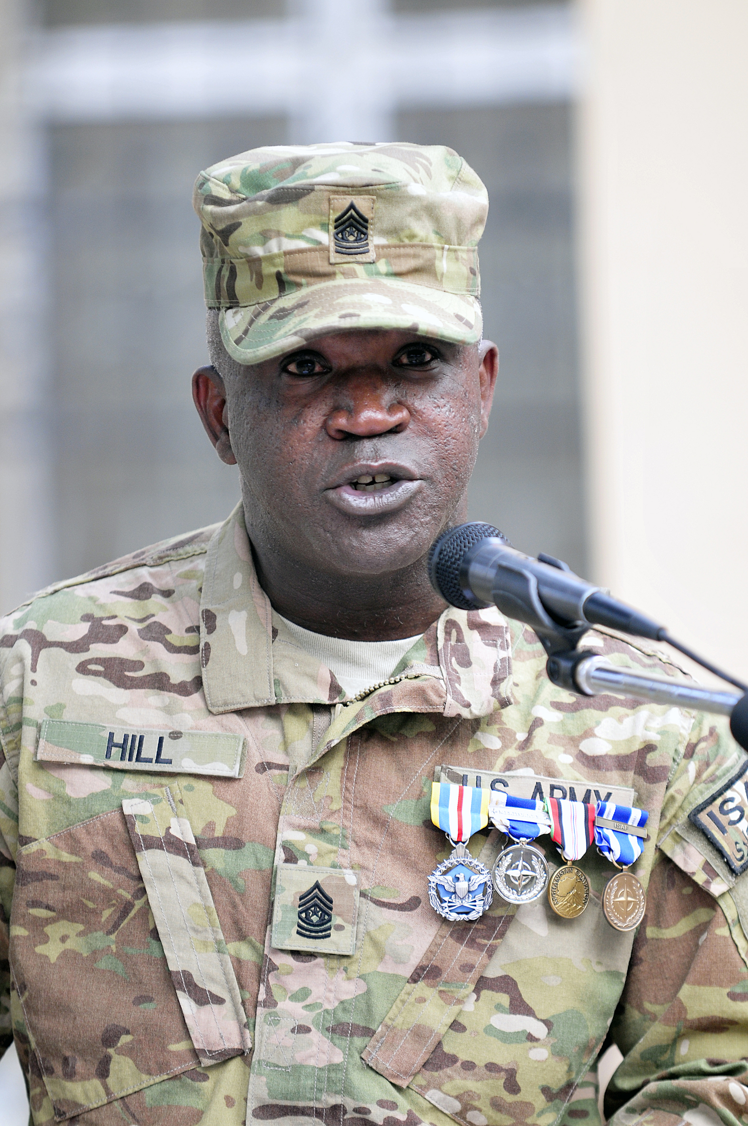 a military man speaking in front of a microphone