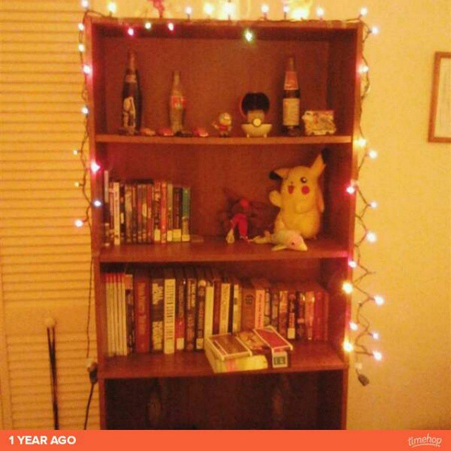 this is a bookshelf decorated with decorations, lights and a stuffed animal