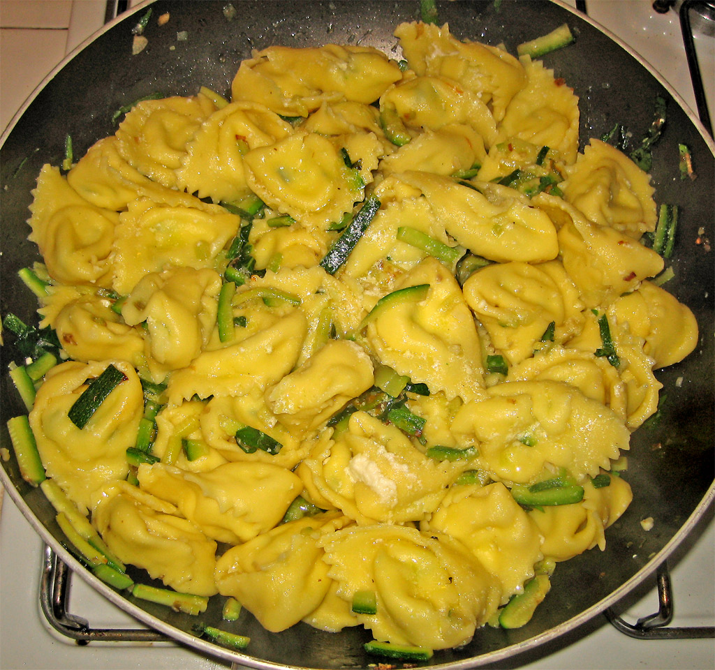 a set filled with ravioli and vegetables on the stove