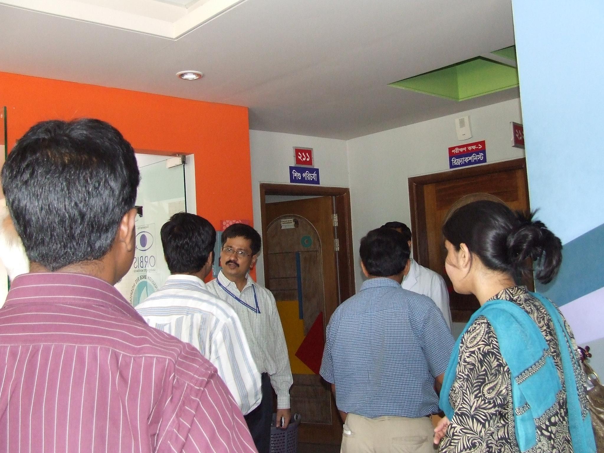 group of people standing in room together with red and blue walls