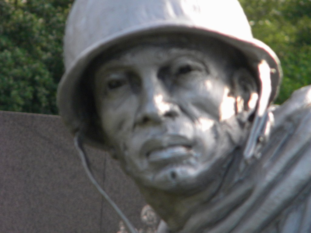 a close up of a statue with a soldier's hat and earphones