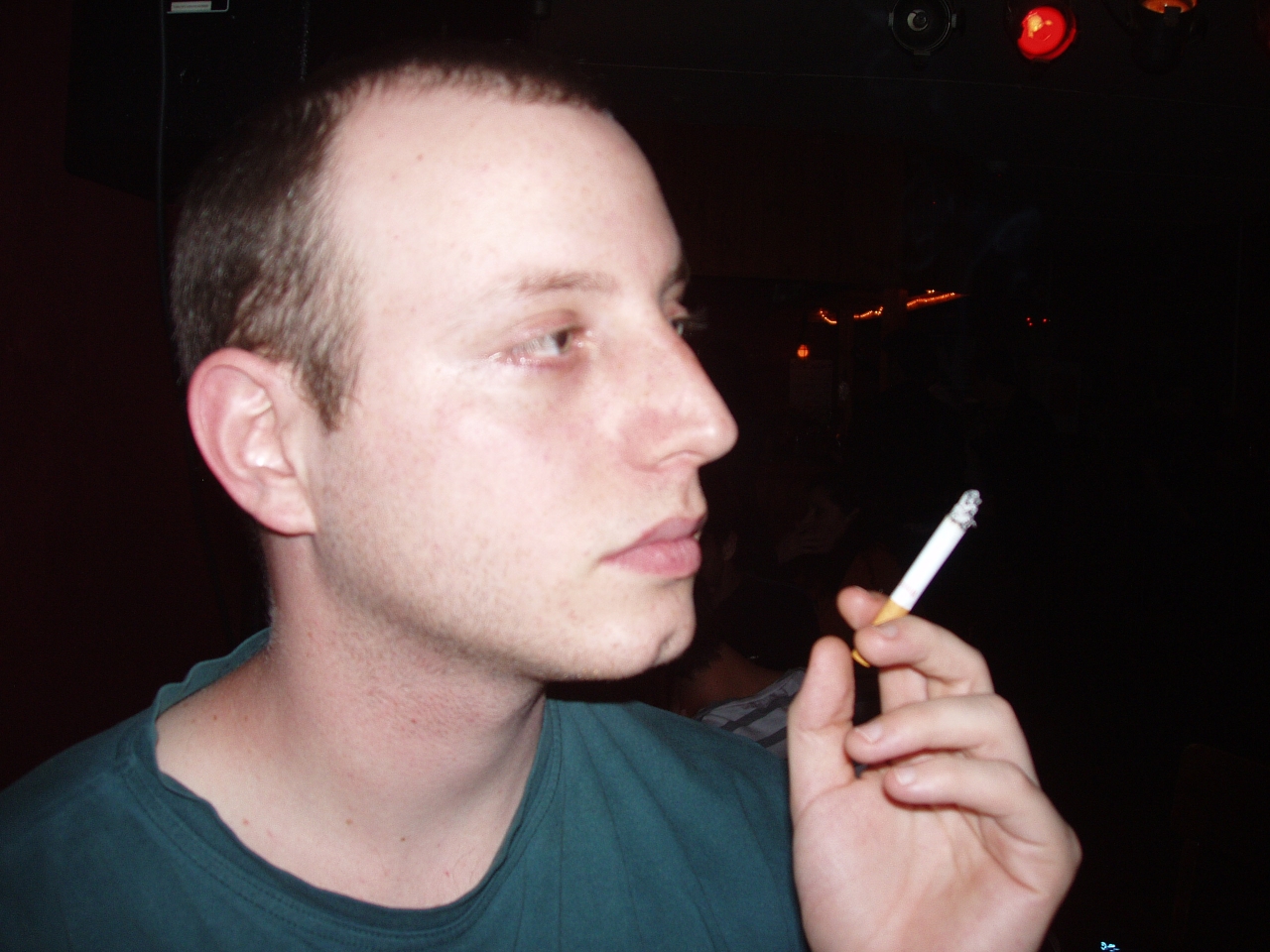 a person who is holding a cigarette up to their mouth